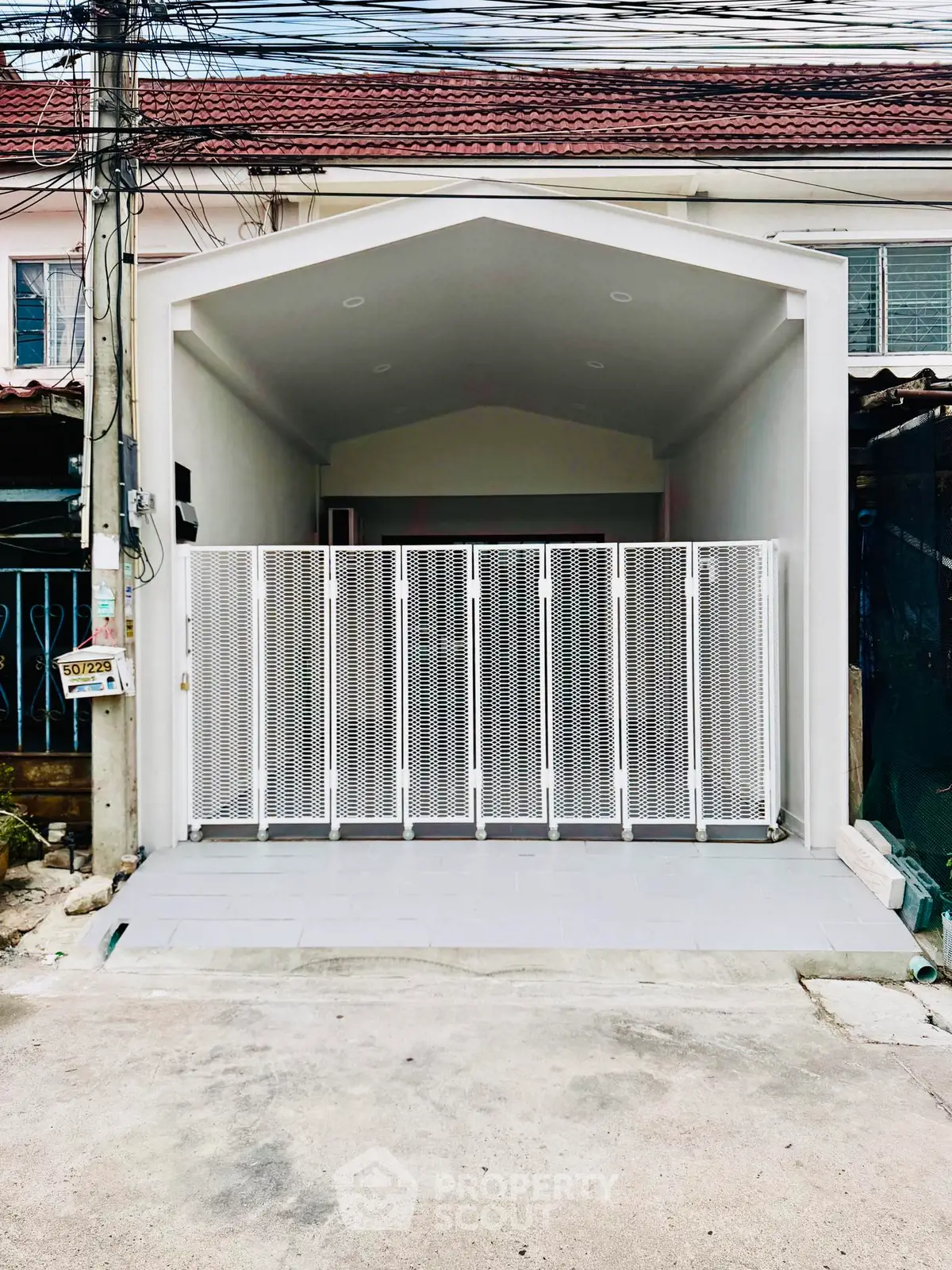Modern minimalist house facade with gated entrance and clean lines, perfect for urban living.