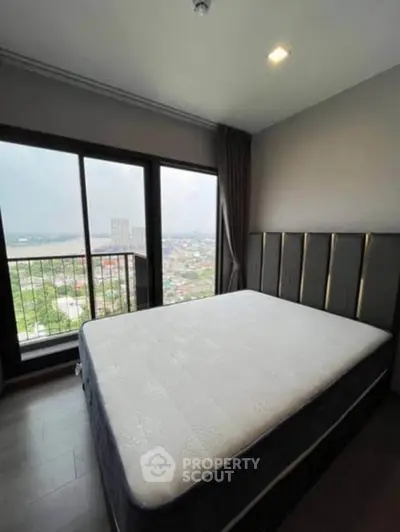 Spacious bedroom with large window offering stunning city view