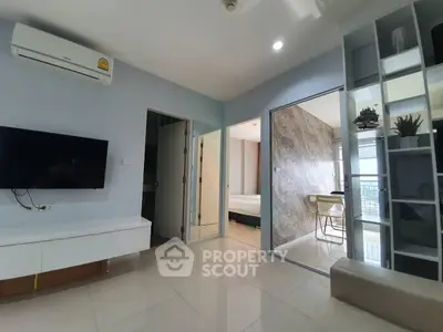 Modern living room with sleek design and open layout, featuring a wall-mounted TV and air conditioning.