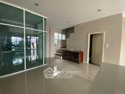 Spacious modern living room with glass partition and sleek staircase