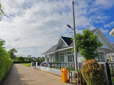 Charming suburban house with lush greenery and spacious driveway under a clear blue sky.
