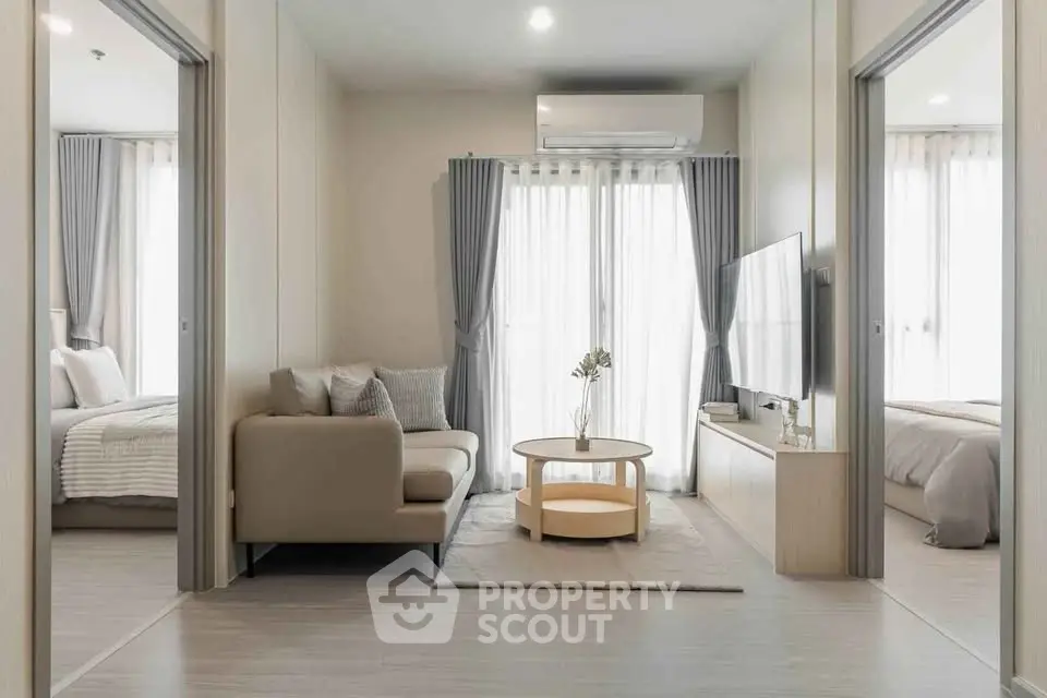 Modern living room with cozy sofa, stylish decor, and natural light from large windows.