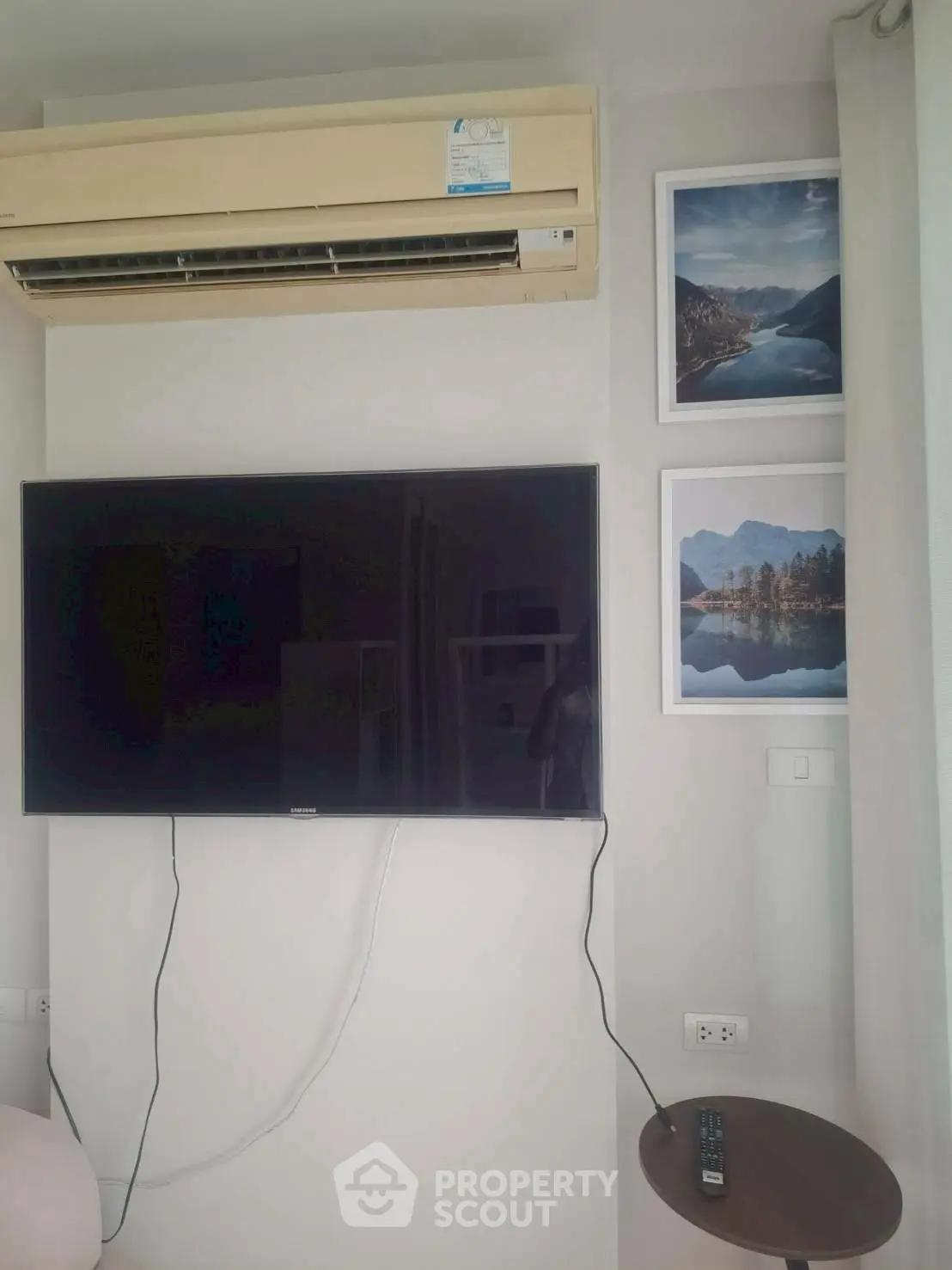 Modern living room with wall-mounted TV and air conditioning unit