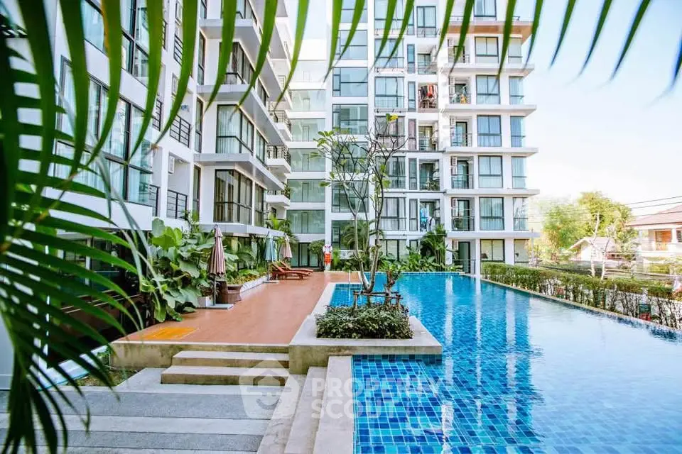 Modern apartment complex with a luxurious outdoor pool and lush greenery.