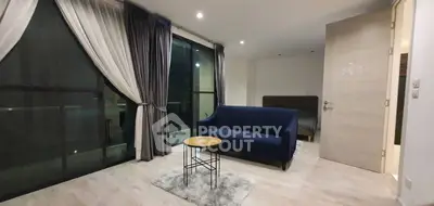 Modern living room with stylish sofa and floor-to-ceiling windows in a contemporary apartment.
