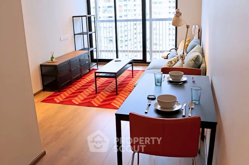 Modern living room with stylish furniture and large windows offering natural light and city views.
