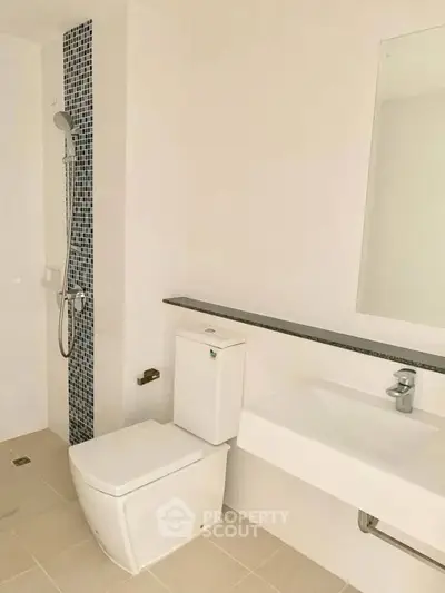 Modern bathroom with sleek fixtures and tiled shower area in a contemporary home.