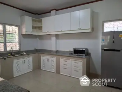 Spacious kitchen with modern cabinetry and stainless steel fridge