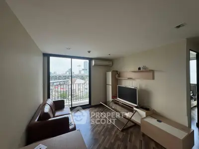 Modern living room with city view, featuring sleek furniture and large windows for natural light.