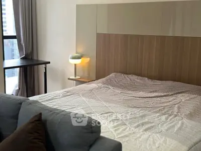 Modern bedroom with stylish decor and large window offering city views