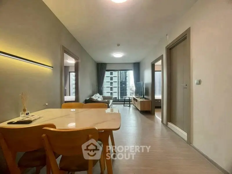 Modern open-plan living and dining area with natural light and balcony view.