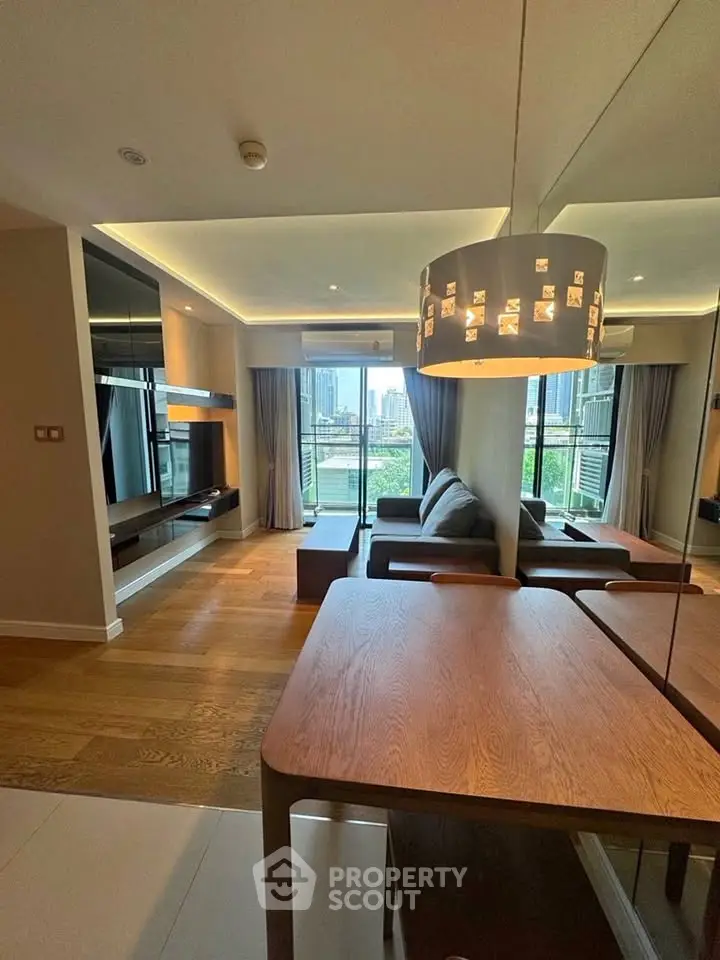 Modern living room with city view, stylish furniture, and elegant lighting in a high-rise apartment.