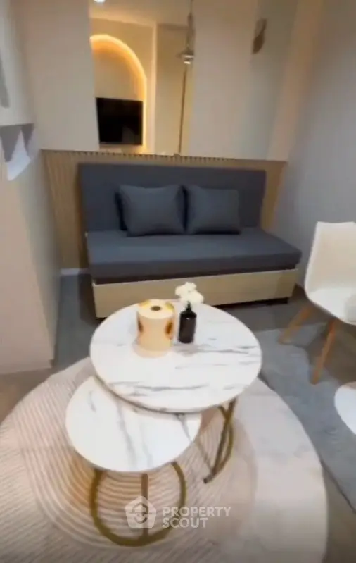 Modern living room with stylish furniture and marble coffee tables in a cozy apartment.