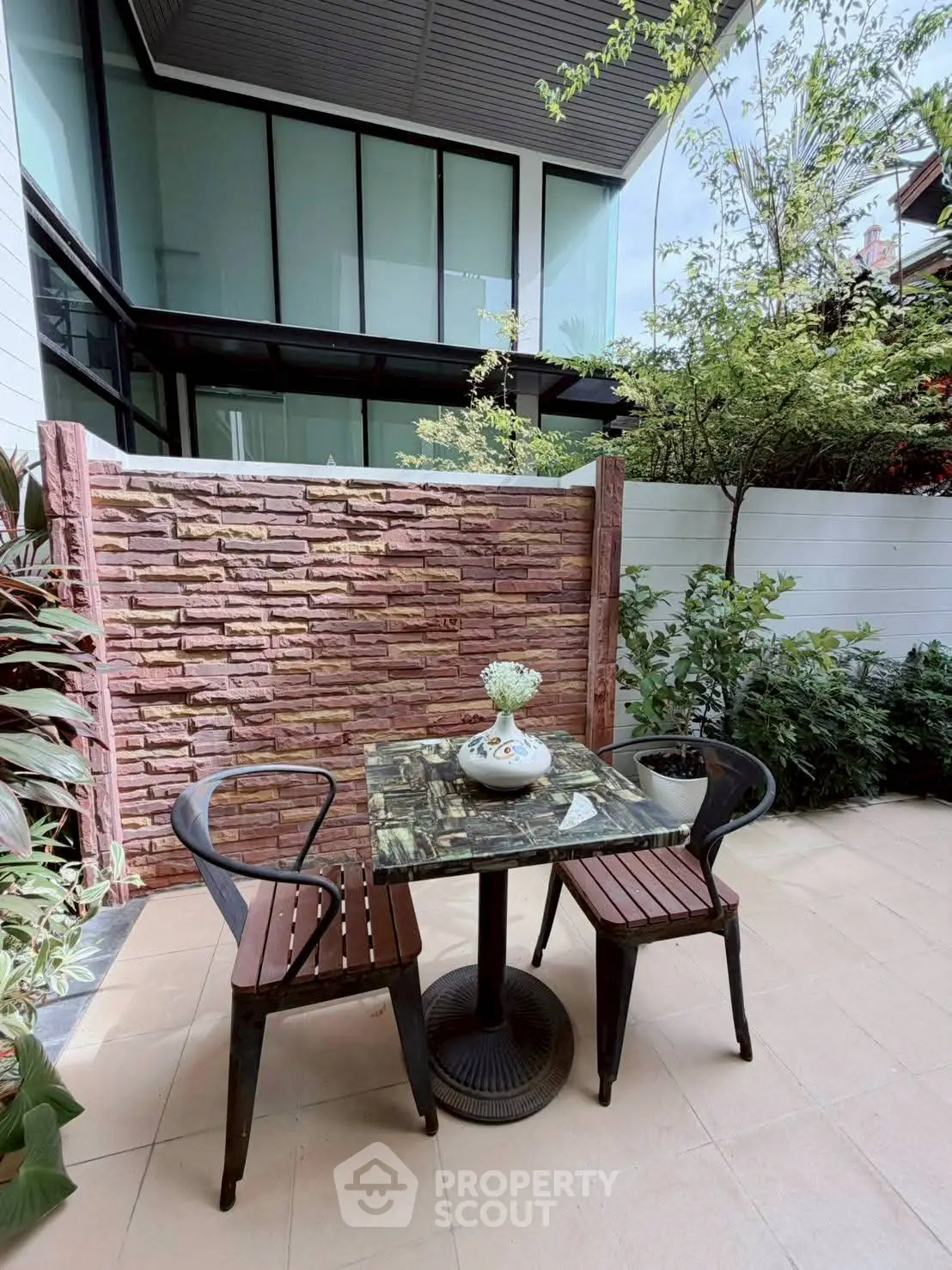Charming outdoor patio with stylish seating and lush greenery, perfect for relaxation and entertaining.