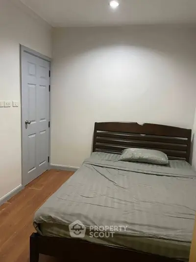 Cozy bedroom with wooden bed frame and minimalist decor, perfect for restful nights.