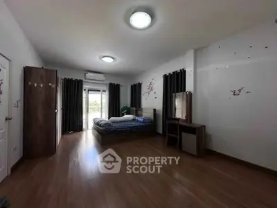 Spacious bedroom with modern decor and natural light, featuring a cozy bed and stylish furniture.