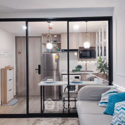 Modern open-layout kitchen with sleek appliances and cozy dining area in stylish apartment.