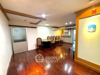 Spacious dining area with elegant wooden flooring and modern lighting