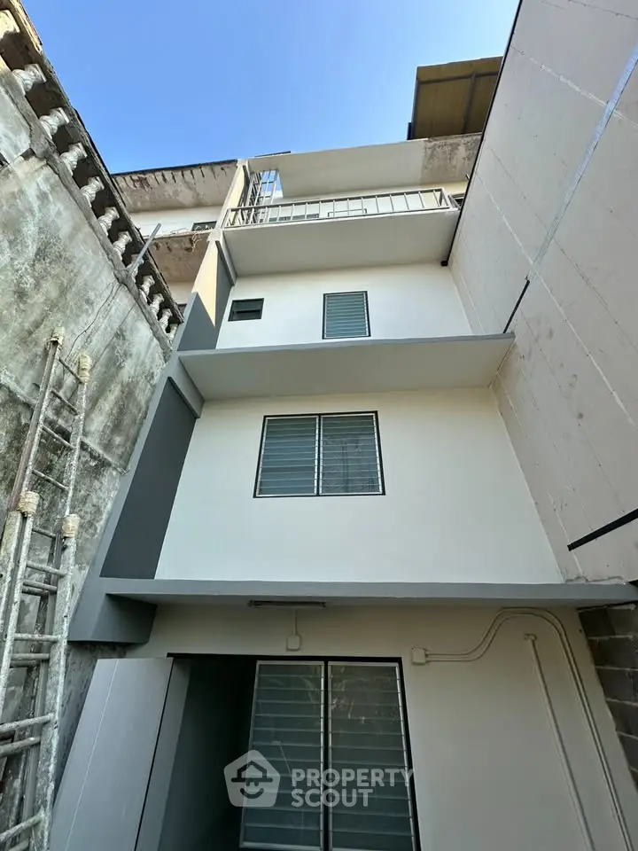 Modern multi-story building exterior with clean lines and large windows, ideal for urban living.