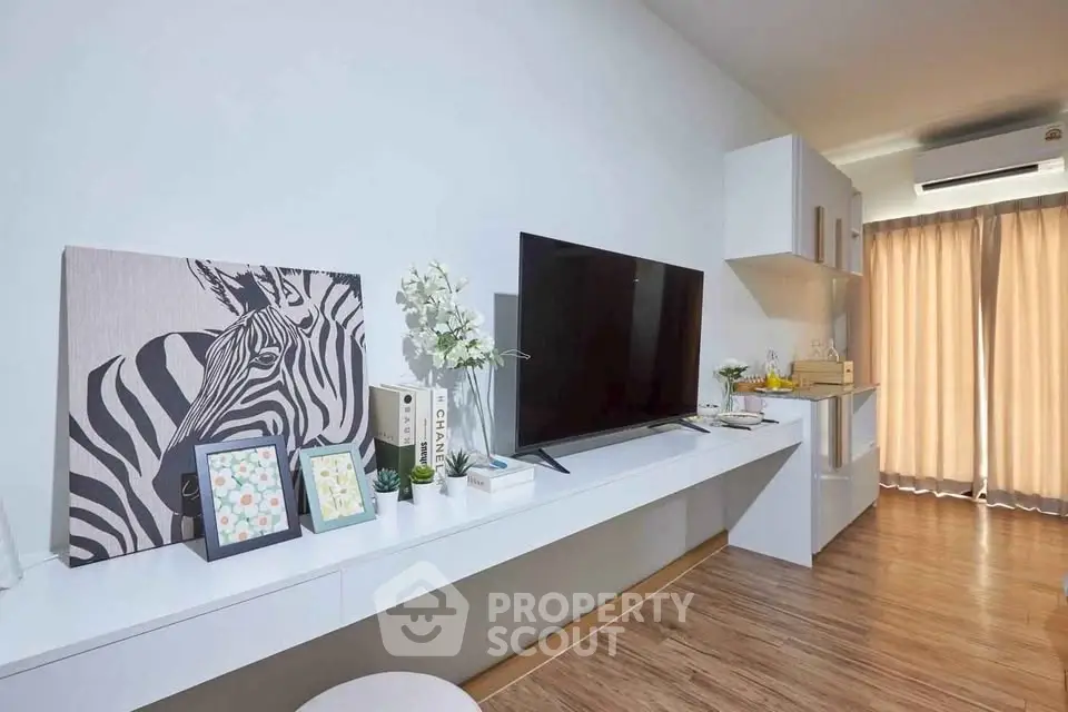 Modern living room with sleek TV setup and stylish decor in a bright apartment.