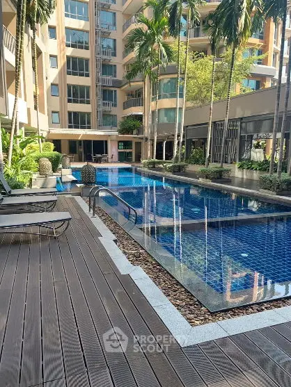Luxurious apartment complex with stunning pool and lush garden area.