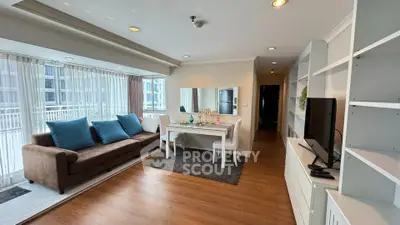 Spacious living room with modern decor and large windows in a stylish apartment.