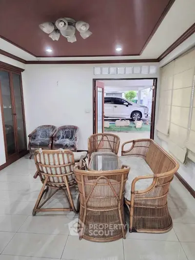 Charming living room with rattan furniture and open view to driveway
