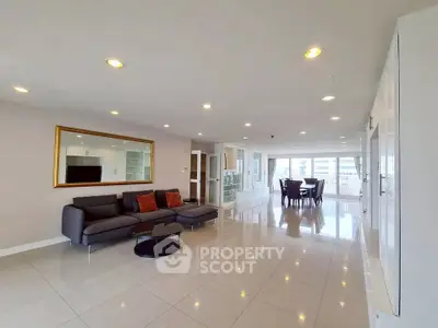 Spacious modern living room with sleek furniture and large windows offering abundant natural light.