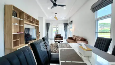 Spacious modern living room with elegant dining area and large windows offering natural light.