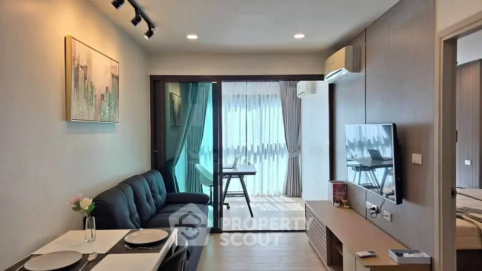 Modern living room with balcony, featuring sleek furniture and natural light, perfect for urban living.