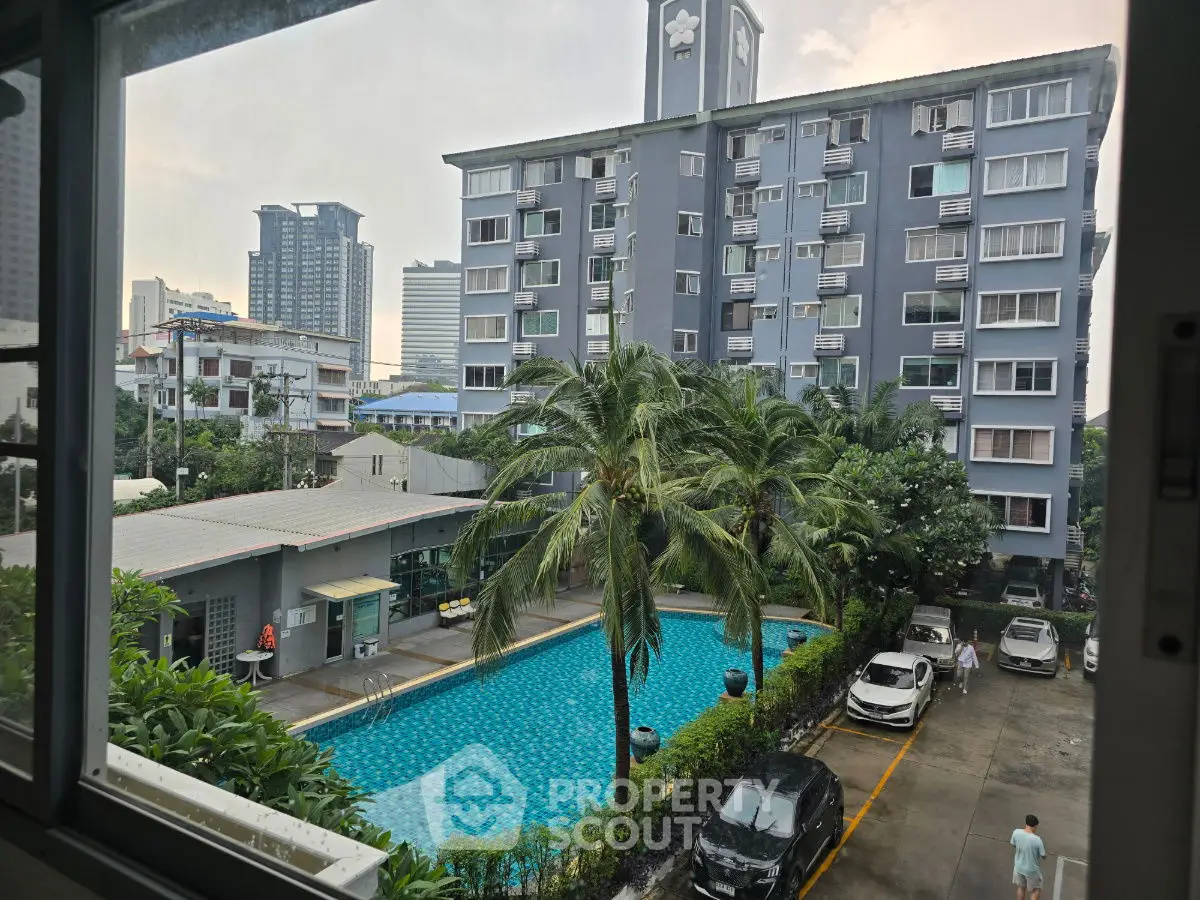 Modern apartment building with pool view and lush greenery, perfect for urban living.