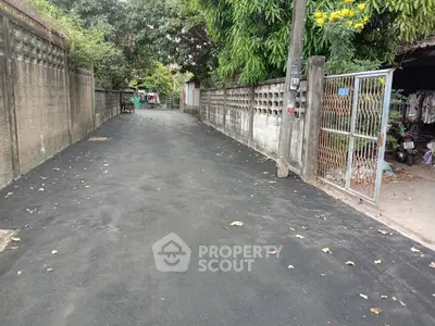 Quiet residential alley with newly paved road and lush greenery