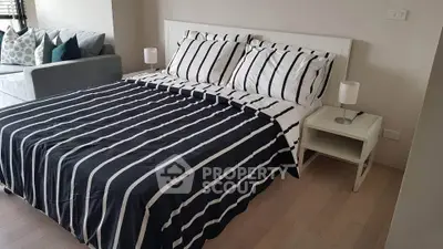 Modern bedroom with stylish striped bedding and cozy ambiance
