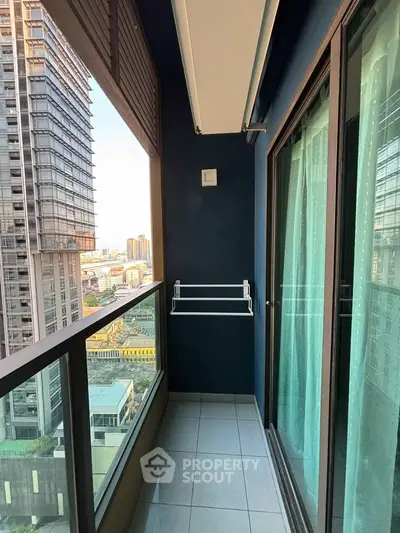 Modern high-rise balcony with city view and glass railing