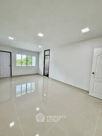 Spacious empty room with glossy tiled floor and bright natural light