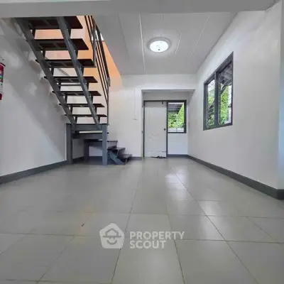 Spacious modern interior with sleek staircase and large windows, perfect for contemporary living.