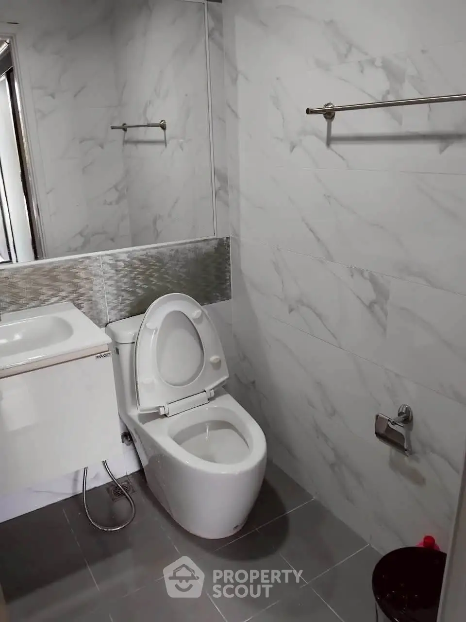 Modern bathroom with sleek design and elegant fixtures, featuring a stylish toilet and sink.