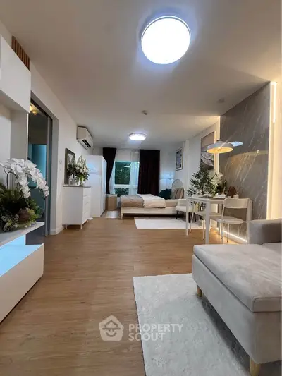 Spacious modern living room with elegant decor and open layout, featuring cozy seating and stylish lighting.