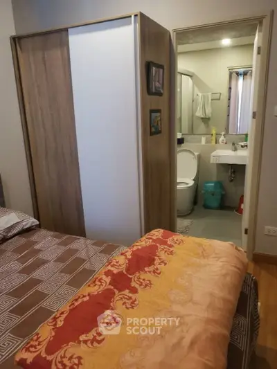 Cozy bedroom with ensuite bathroom featuring modern decor and wooden wardrobe.