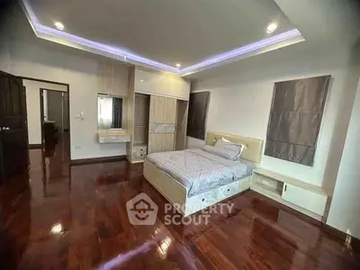Spacious bedroom with polished wooden floors and modern furnishings