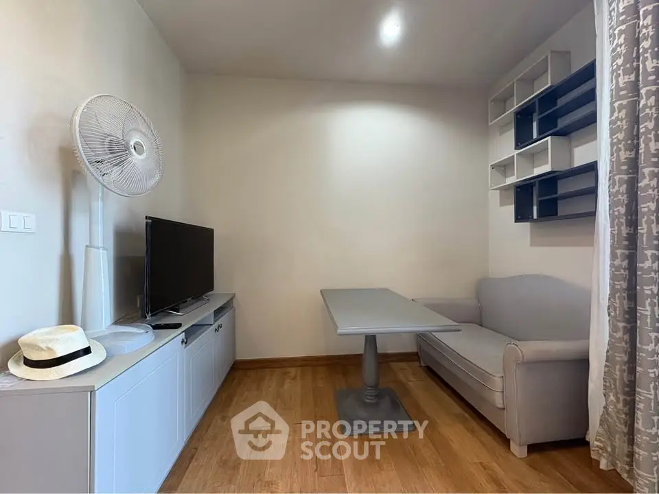 Cozy living room with modern decor, featuring a TV, sofa, and stylish shelving.