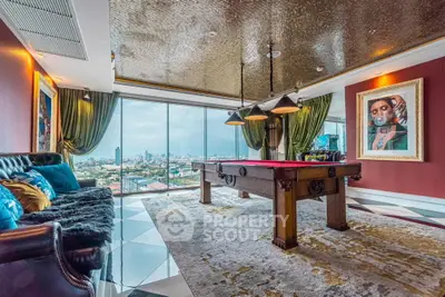 Luxurious living room with pool table and stunning city view, featuring elegant decor and large windows.