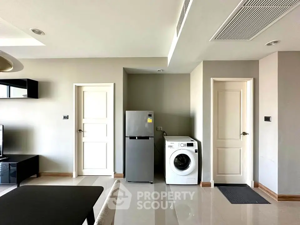 Modern interior with washing machine and fridge in a sleek, minimalist design.