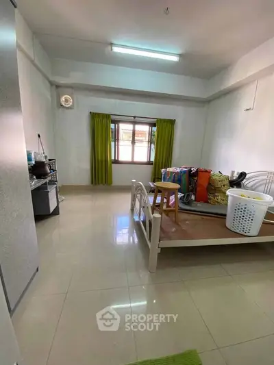 Spacious bedroom with natural light and minimalistic decor, perfect for a cozy living experience.