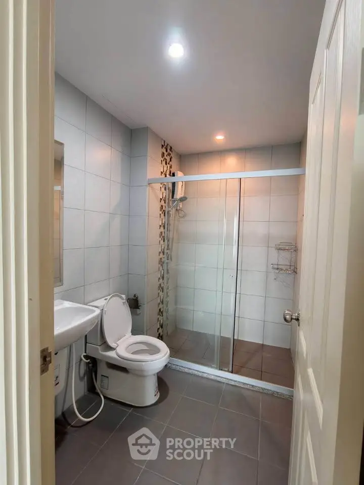 Modern bathroom with glass shower and sleek fixtures in a contemporary home.