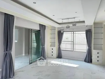 Spacious modern living room with elegant curtains and ample natural light