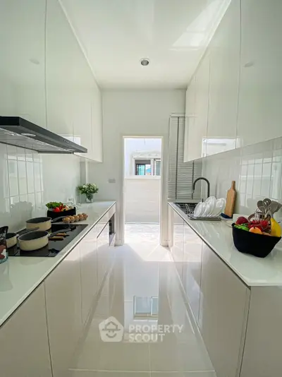 Sleek modern kitchen with glossy white cabinets and open layout design