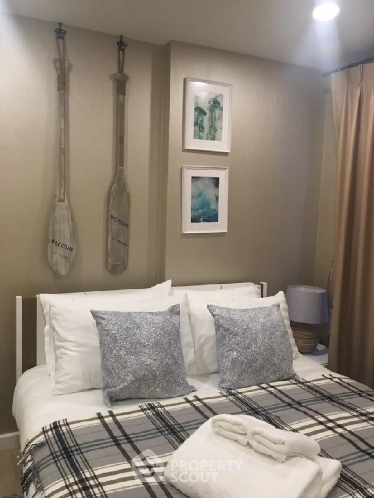 Cozy bedroom with nautical decor and plaid bedding in modern apartment