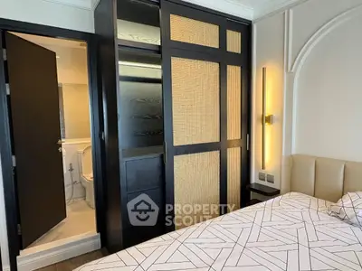 Modern bedroom with stylish closet and en-suite bathroom, featuring elegant lighting and contemporary design.