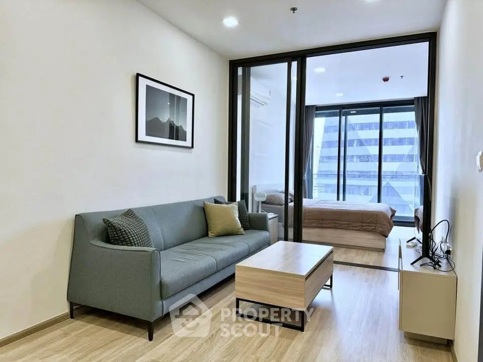 Modern living room with sleek sofa and view into stylish bedroom